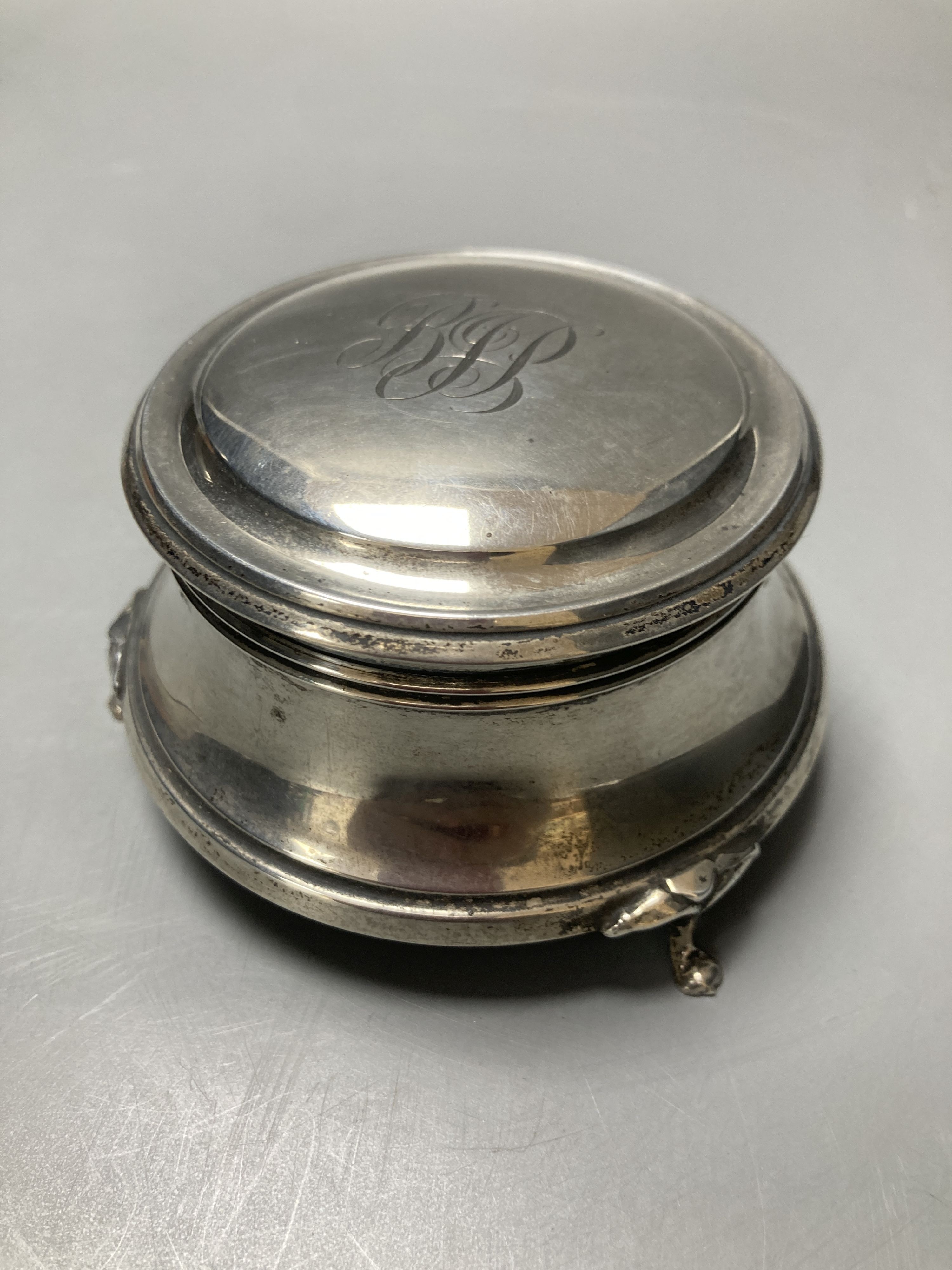 A silver cigar box, London 1928, 18cm, a silver ring box, Birmingham 1925, 9 cm diameter, and a silver topped pin box, 8.5 cm wide